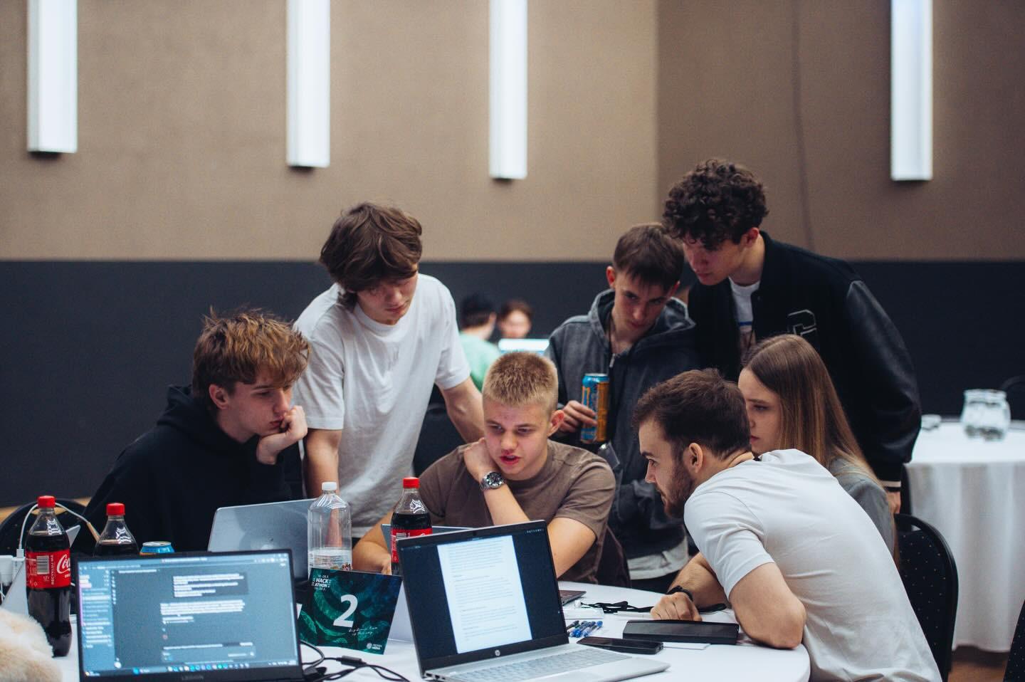 The team gathered around laptops working through the build with a mentor